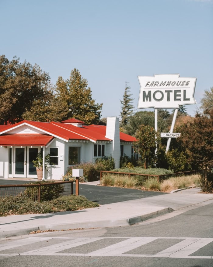 Farmhouse Paso Roble Exterior of Farmhouse Paso Robles - white buildings with red roofs and a vintage sign out front.