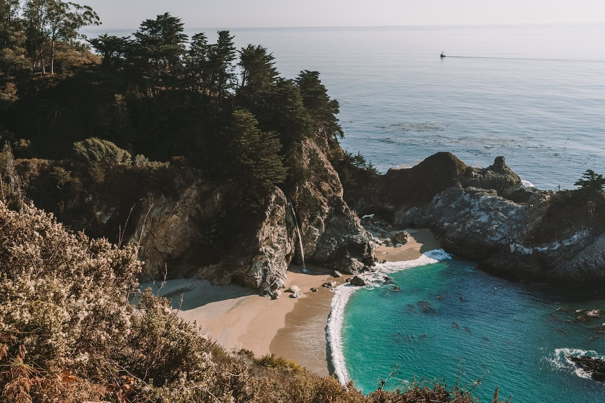 turquoise water Dramatic cove with a waterfall that runs off directly into the beach and is surrounded by turquoise water