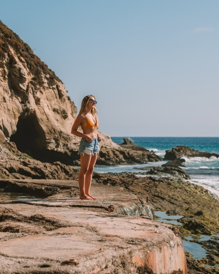 cave formation on the beach Michelle Halpern standing in a rock pool in front of a cave formation on the beach