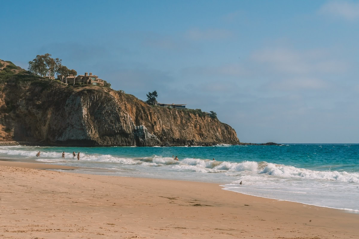 Turquoise water and yellow sand Turquoise water and yellow sand on the beach backed by a tall cliff with a house on it.