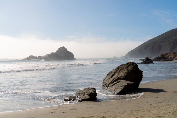shore at Pfeiffer Beach Large rock formations jutting out of the sand close to the shore at Pfeiffer Beach