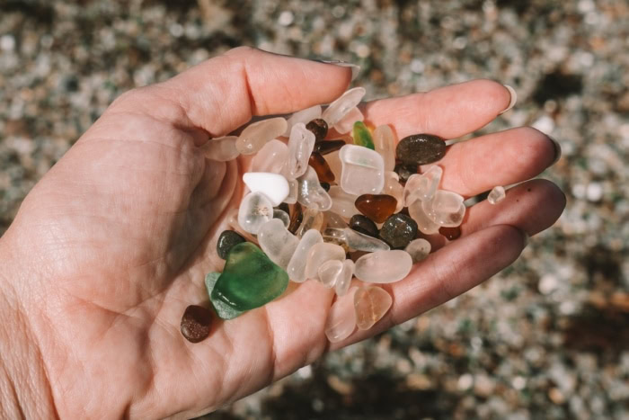 sea glass Hand picking up sea glass of different colors from Glass Beach in Fort Bragg