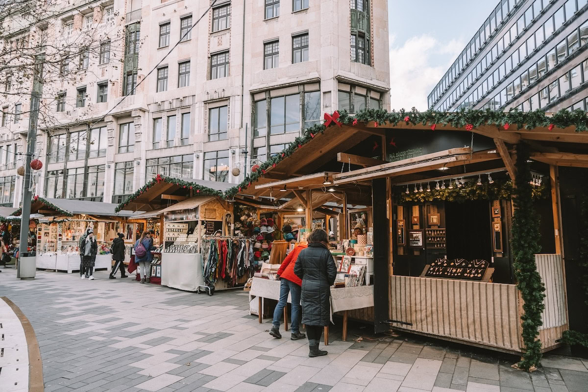 holiday goods at the wooden stalls People looking at holiday goods at the wooden stalls of a Christmas Market