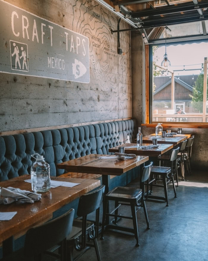 Pipeline Craft Tap & Kitchen interior Interior at Pipeline Craft Tap & Kitchen featuring dark blue booths with brown tables