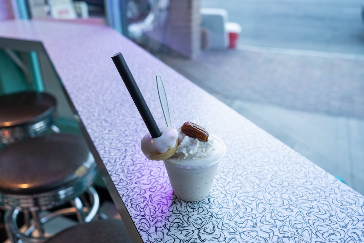 Date shake Date shake sitting on a countertop with a mini donut, whip cream and date decorating the top