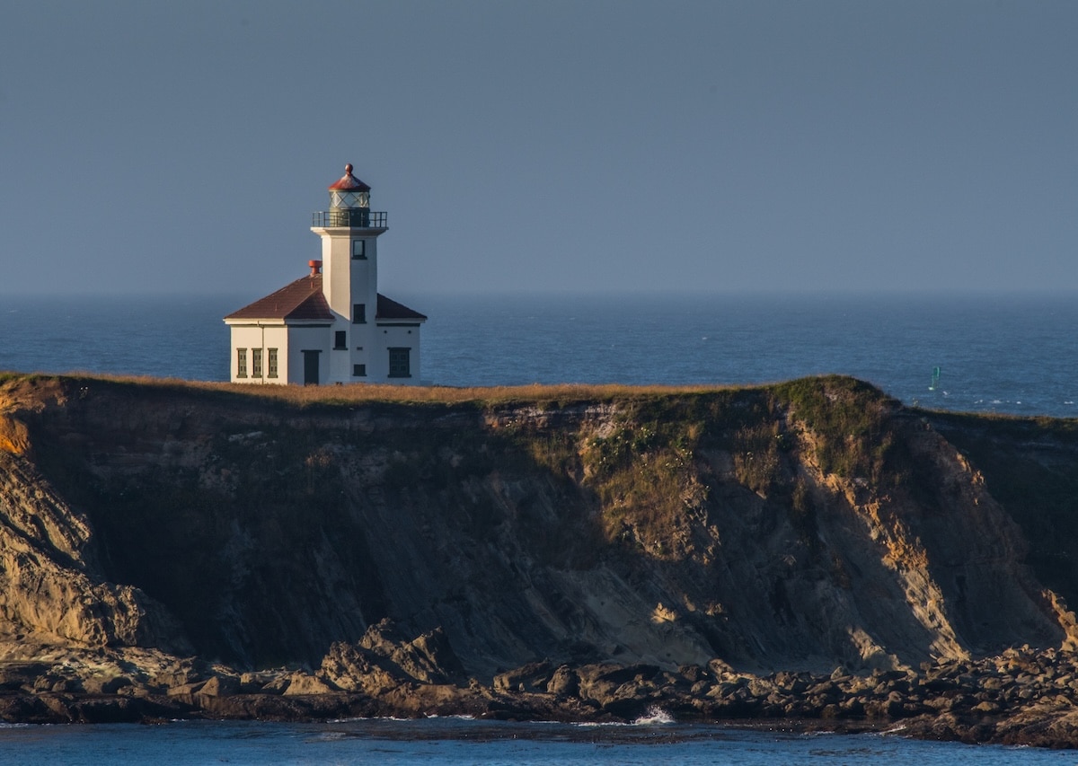 Best Oregon Coast Towns Cape Arago Lighthouse perched on a cliff near Coos Bay, one of the Best Oregon Coast Towns