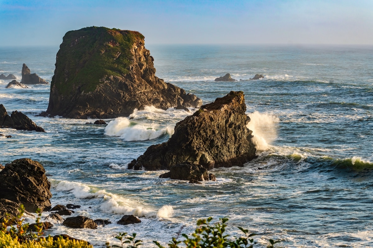 Best Oregon Coast Towns Waves crashing against sea stacks in Brookings, Oregon