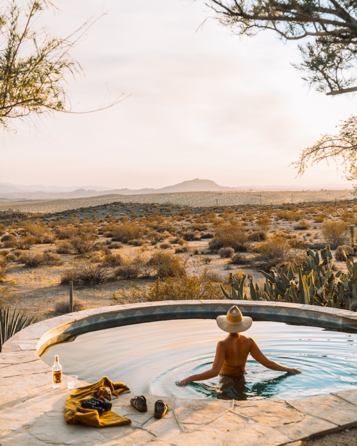 Joshua Tree desert landscape Michelle Halpern wading in a round pool looking out onto the Joshua Tree desert landscape