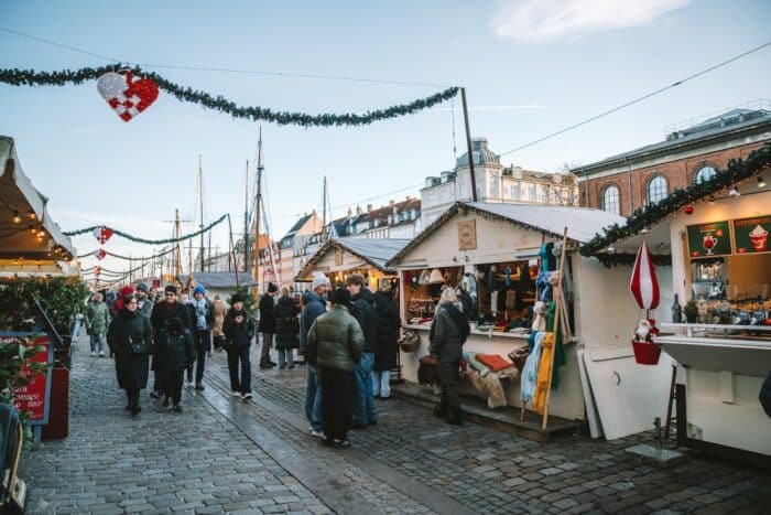 Festively decorated pedestrian walk lined with holiday vendors in Nyhavn