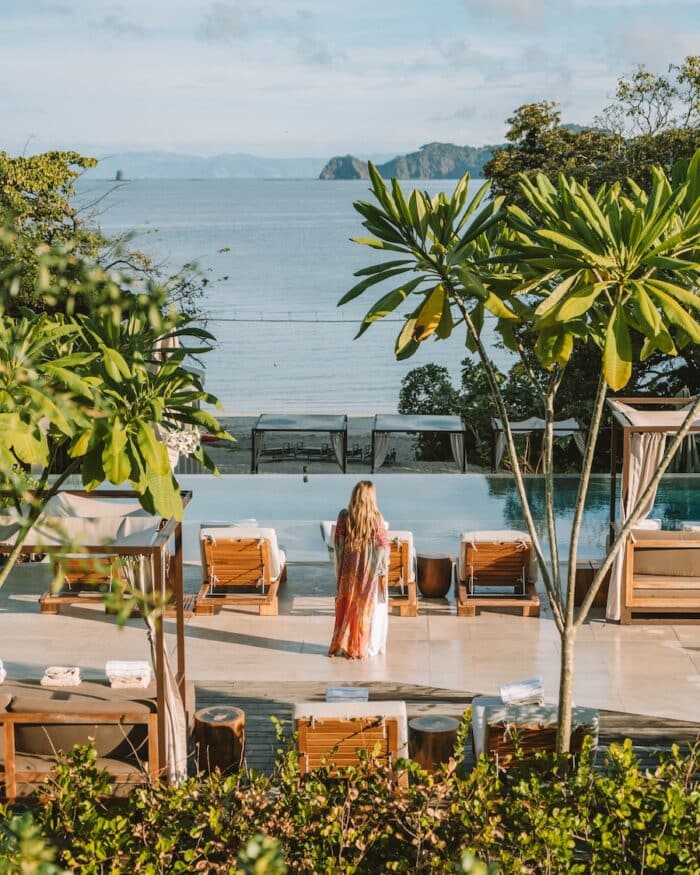Michelle Halpern standing on pool terrace looking out to the ocean in Costa Rica.