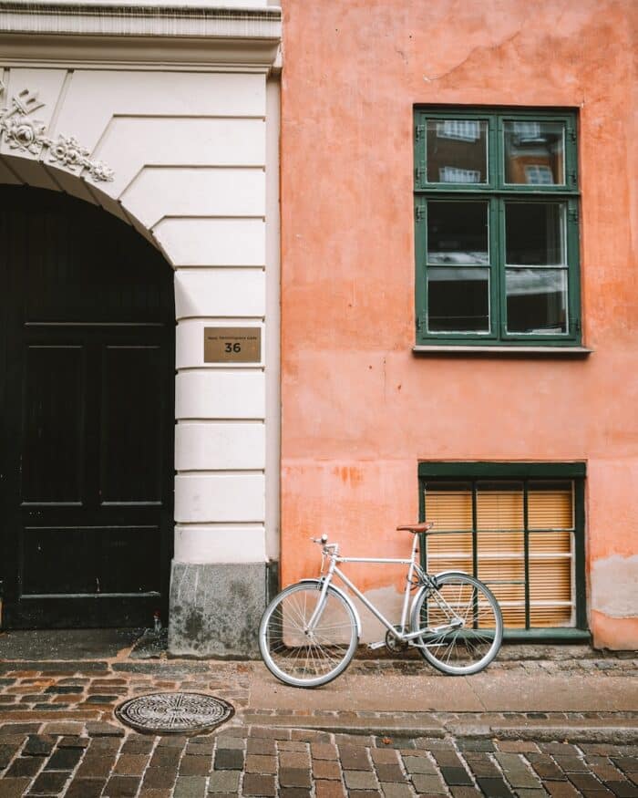 two-toned building Bike leaning up against a two-toned building - left side is white and right side is salmon colored