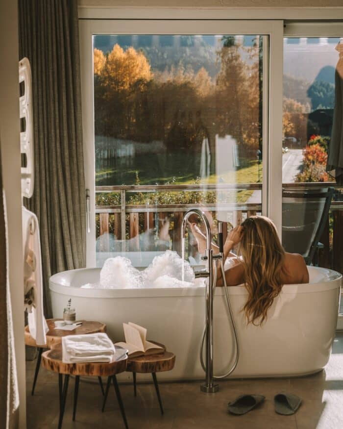 bathtub at Hotel Petrus Michelle Halpern in bathtub at Hotel Petrus looking out window to autumn trees