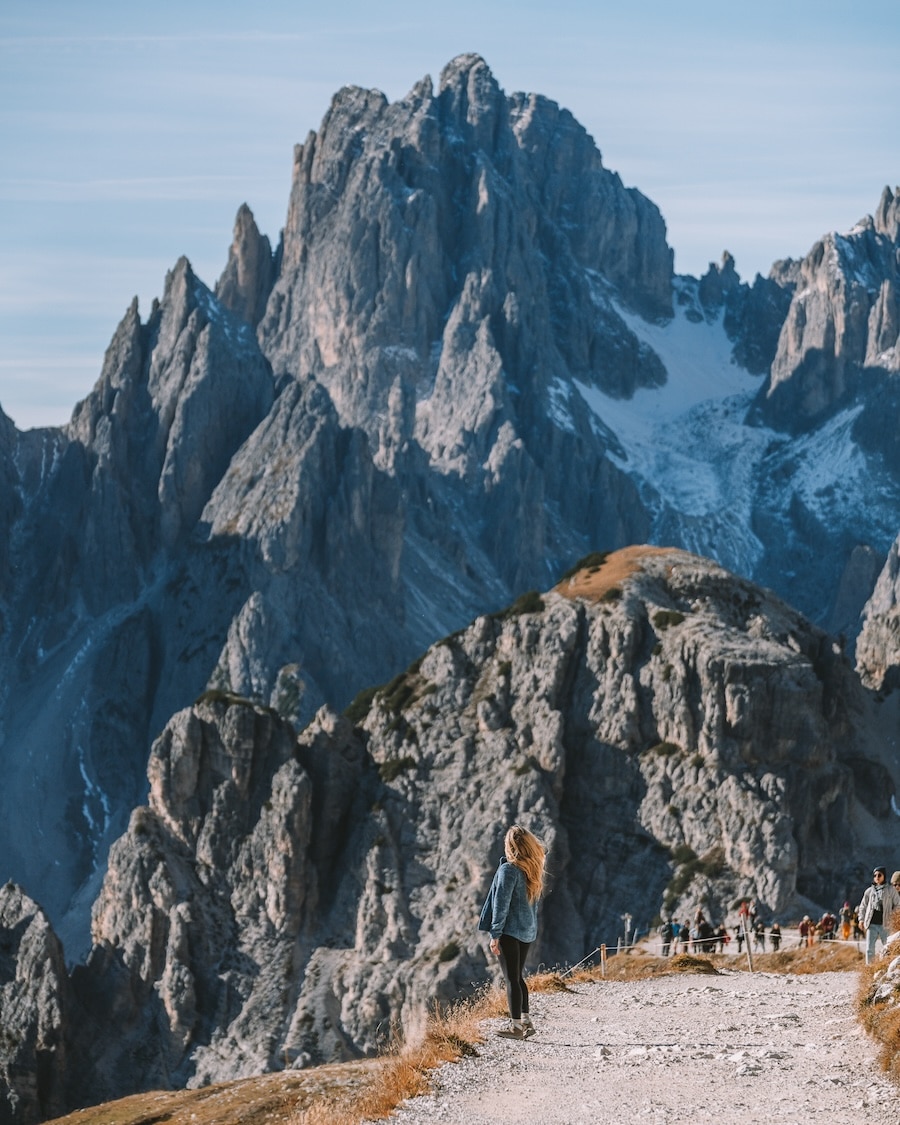 Tre Cime di Lavaredo trail Michelle Halpern standing along the Tre Cime di Lavaredo trail with jagged mountain peaks behind her