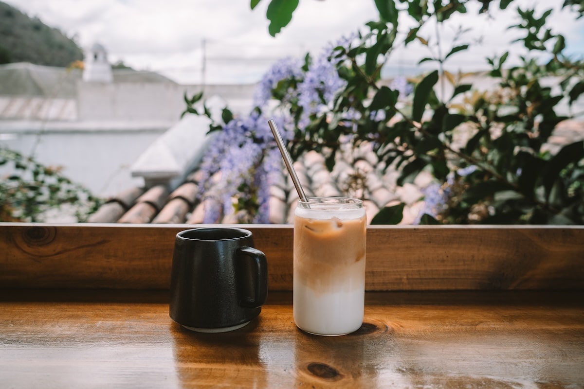 Iced coffee and hot coffee Iced coffee and hot coffee sitting on a table with lavender flowers behind them.