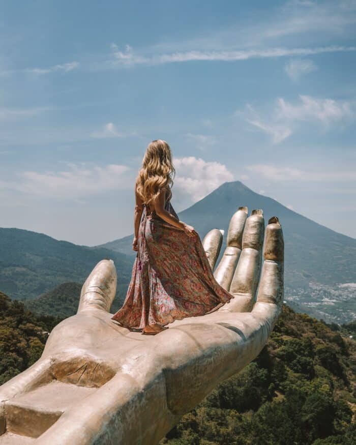 golden hand at Altamira park Michelle Halpern standing on golden hand at Altamira park in Antigua