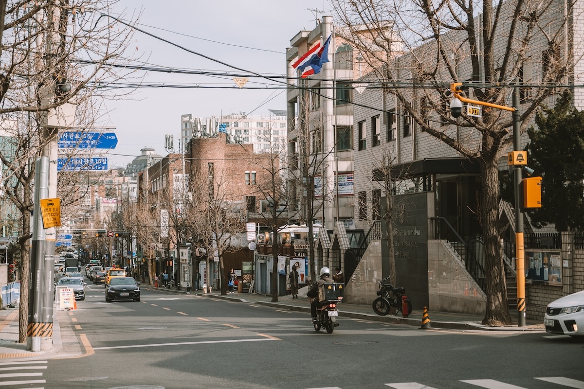 Street scene in Itaewon Seoul Street scene in Itaewon Seoul with cars driving by and a moped rider in the center