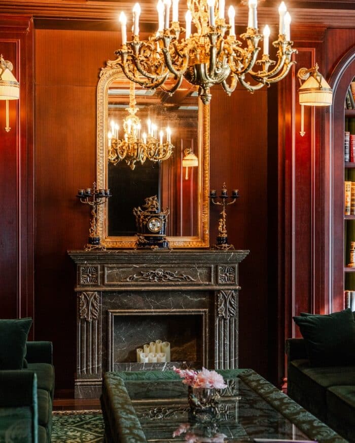 Fireplace Fireplace with a rounded mirror on top of it and a chandelier hanging from the ceiling