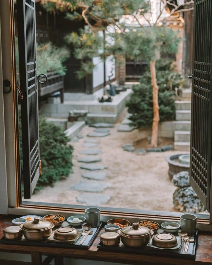 traditional Korean dishes Large spread of traditional Korean dishes in front of a window looking out into a courtyard at Rakkojae Seoul
