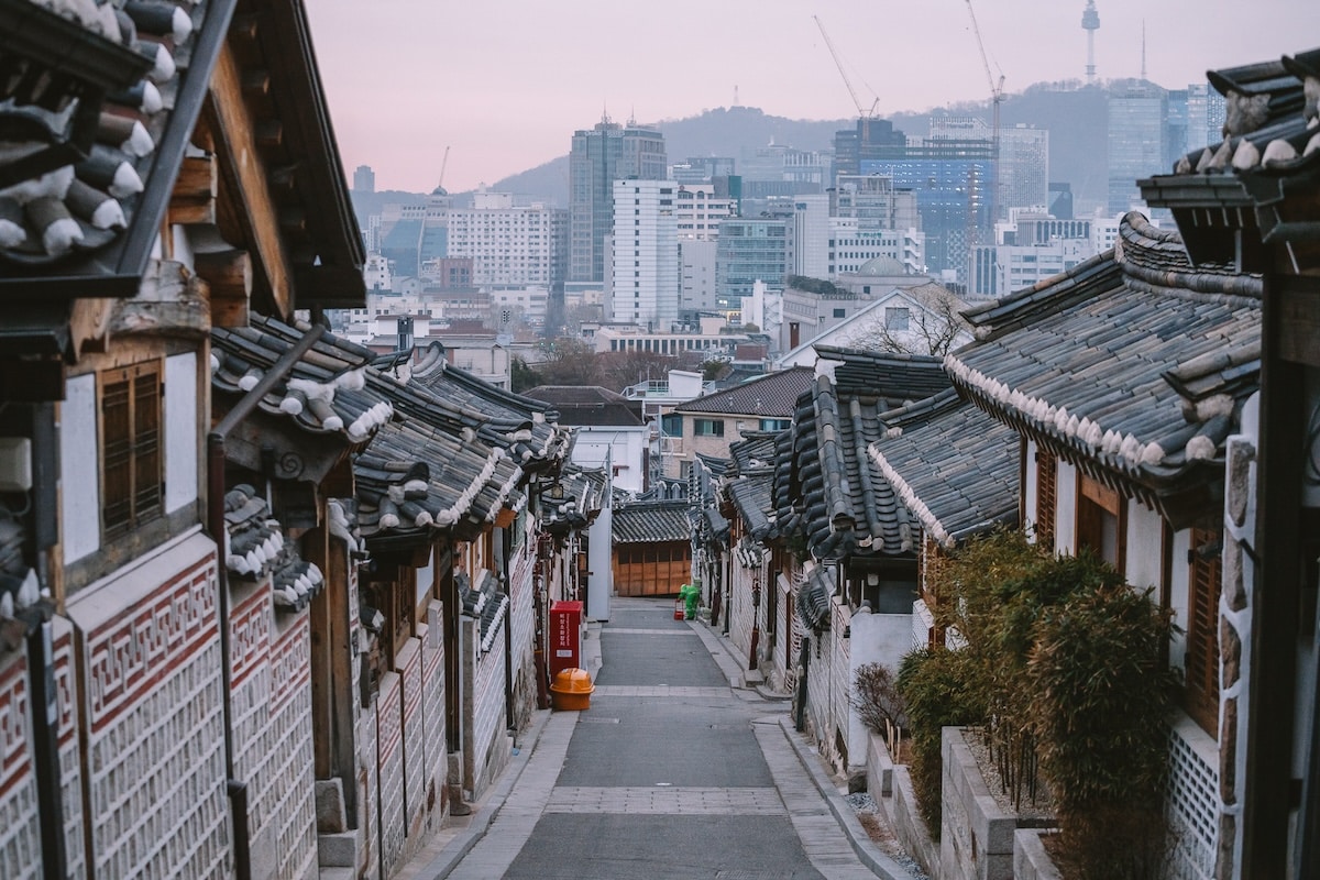 Bukchon Hanok Village Pink glow over the city skyline from inside Bukchon Hanok Village in Seoul featuring traditional Korean houses or hanoks