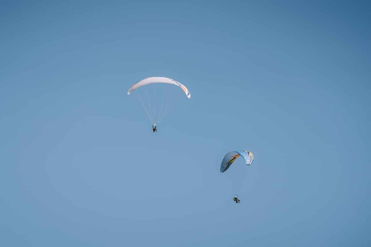 paragliders mid flight Two paragliders mid flight against the blue sky