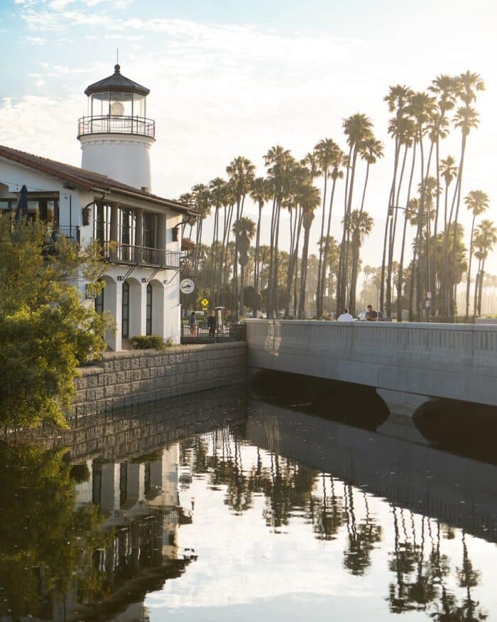 Lighthouse building Lighthouse building on the Santa Barbara waterfront next to a line of palm trees reflected in the water
