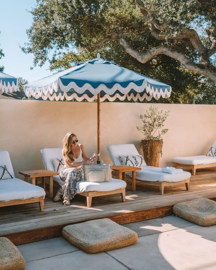 Hotel Ynez Michelle Halpern sitting on a pool lounger opening a tote bag at the Hotel Ynez