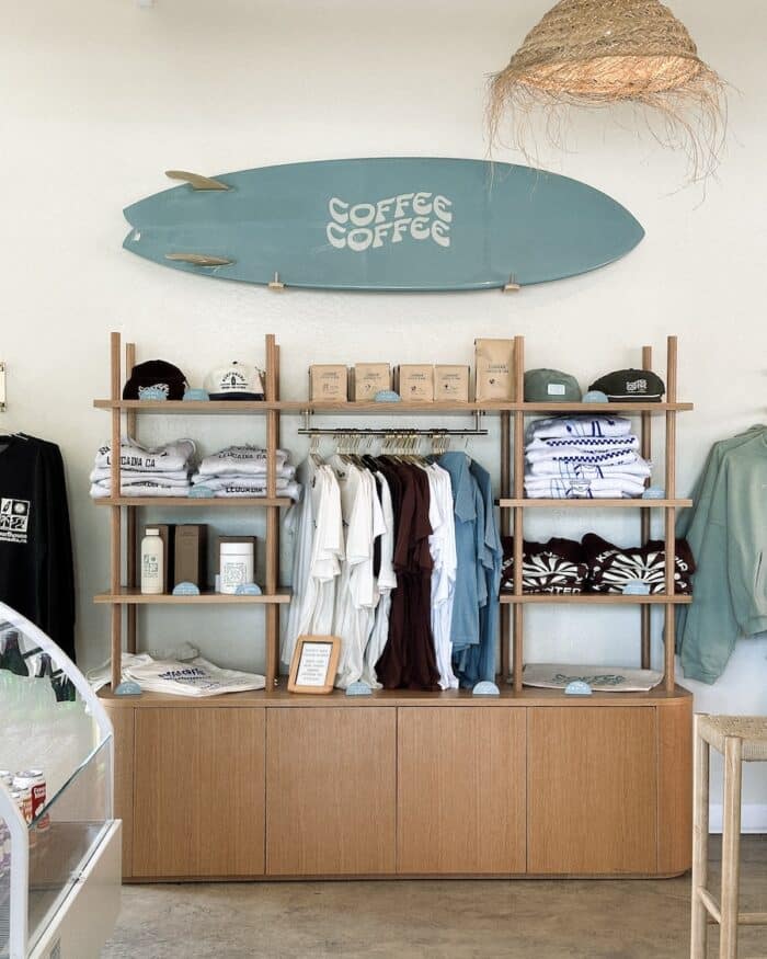 Surfboard on wall Surfboard on wall with Coffee Coffee logo over a rack of clothing