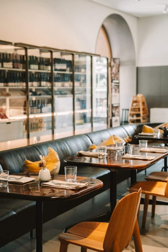 Line of tables and wine Line of tables and wine case in the background at ARTIFACT restaurant at Mingei
