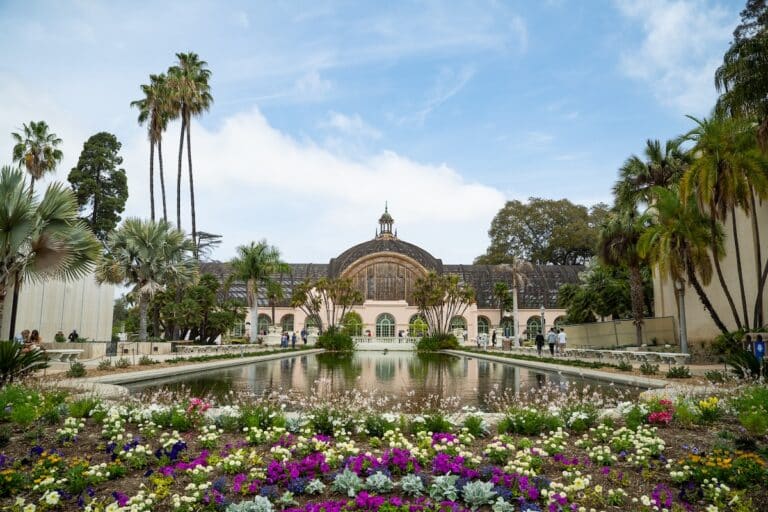 Botanical building in Balboa Park surrounded by flowers and a pond