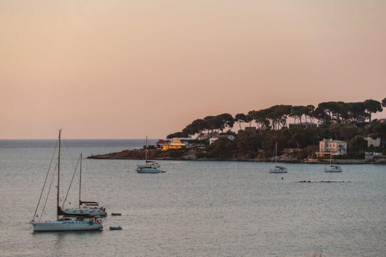 Warm sunset over the coast of Cap d'Antibes with sailboats in the harbor