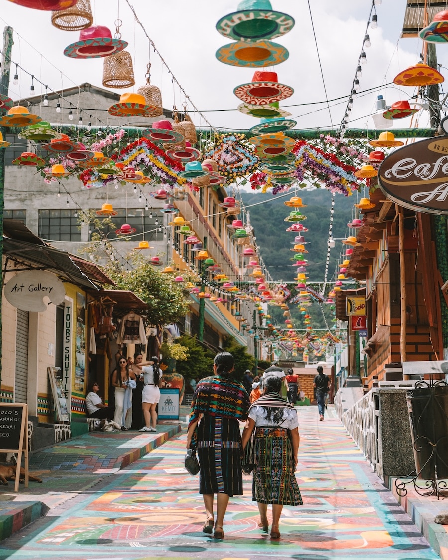 street in San Juan la Lagun Two women walking along a street in San Juan la Laguna that is lined with a ceiling of hanging hats