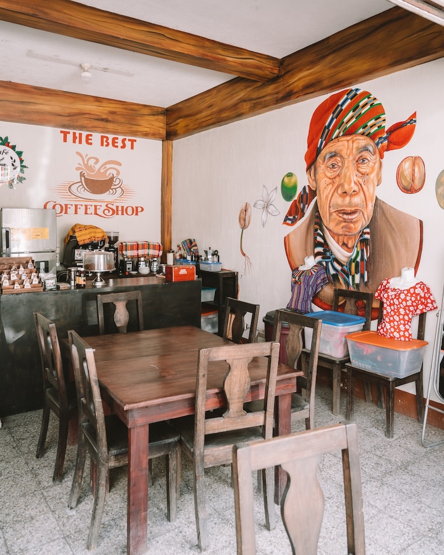 Interior of Cafe Esencia Interior of Cafe Esencia featuring wooden tables and a large mural of a man on the wall