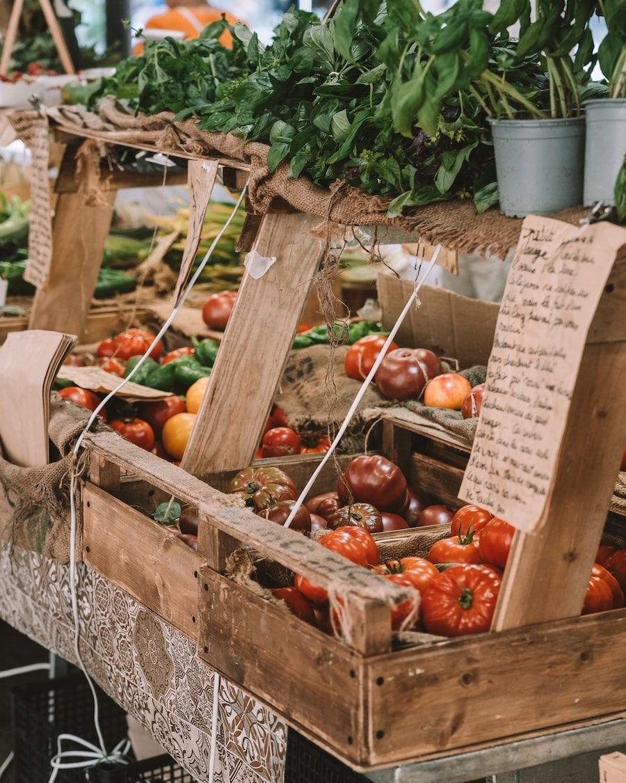 tomatoes and basil Produce stand filled with tomatoes and basil and handwritten descriptions