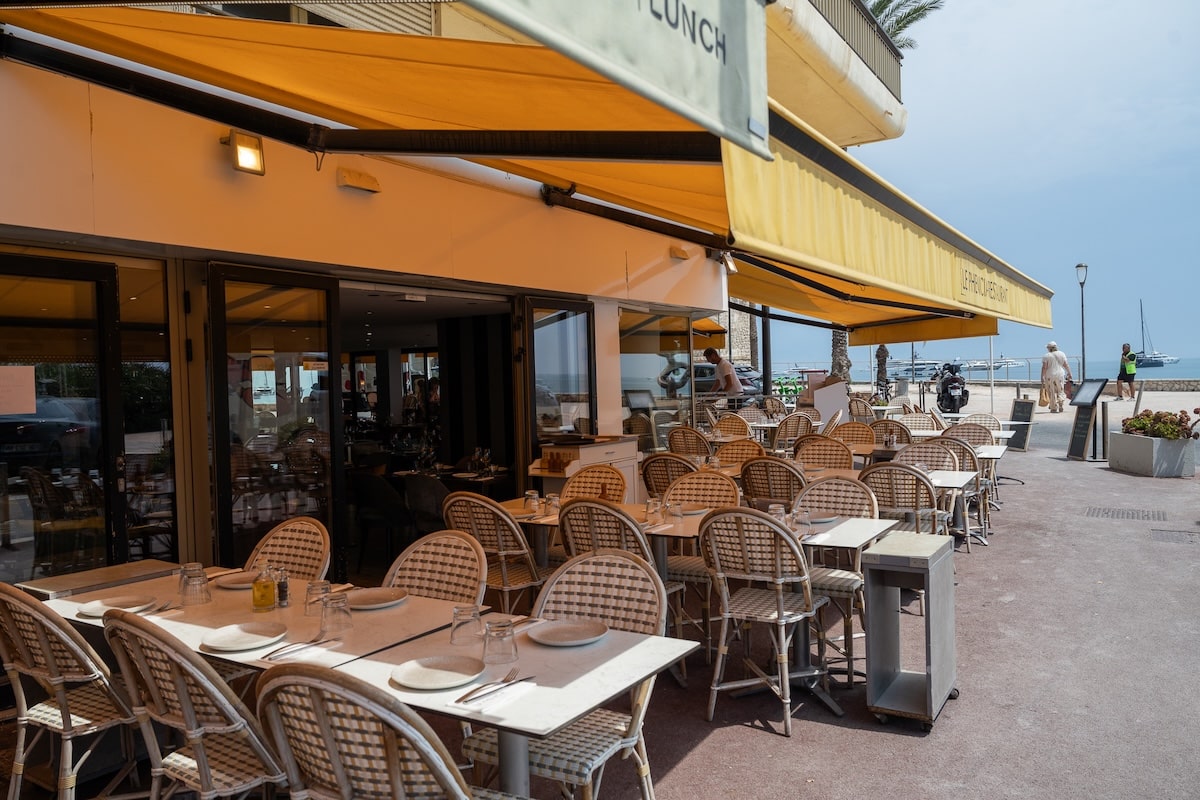 Le Phoenicia restaurant in Antibes Yellow awning and french bistro chairs set up at Le Phoenicia restaurant in Antibes