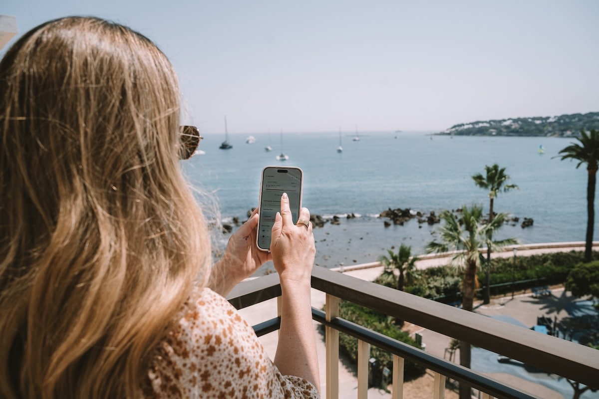 phone installing an eSIM Michelle Halpern holding a phone installing an eSIM while standing on a balcony that overlooks the sea